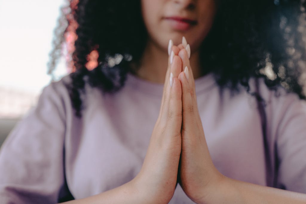 A serene close-up image of a woman with hands in a praying position, serenity, praying hands